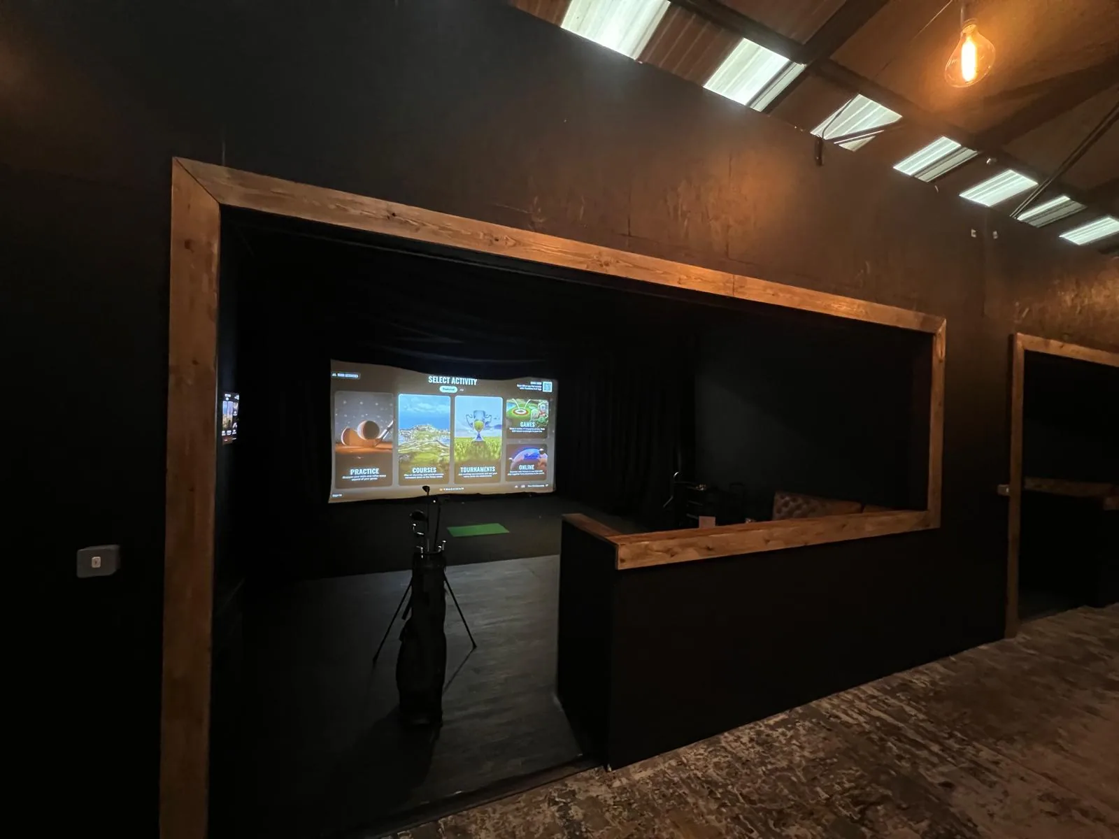 Bar seating with live sport showing on screen at Fliers Indoor Golf, Liverpool