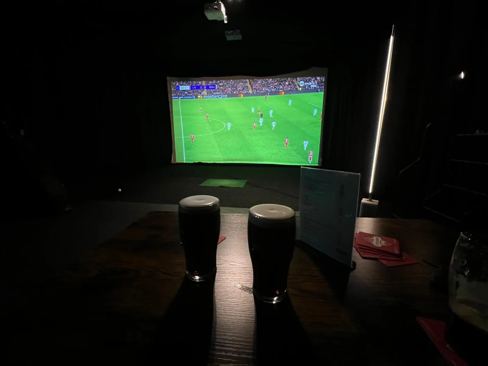 Live sport on the big screen with people watching at Fliers Indoor Golf, Liverpool
